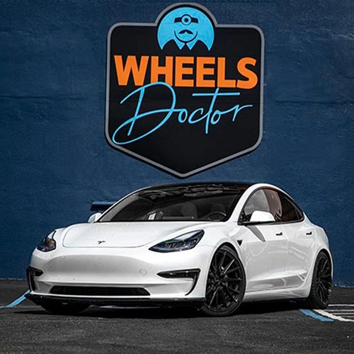 A white Tesla car and on the back the Wheels Doctor Emblem, the Rim car was the Repair for Wheels Doctor team