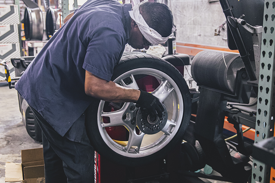 Technician inspecting a damaged alloy wheel