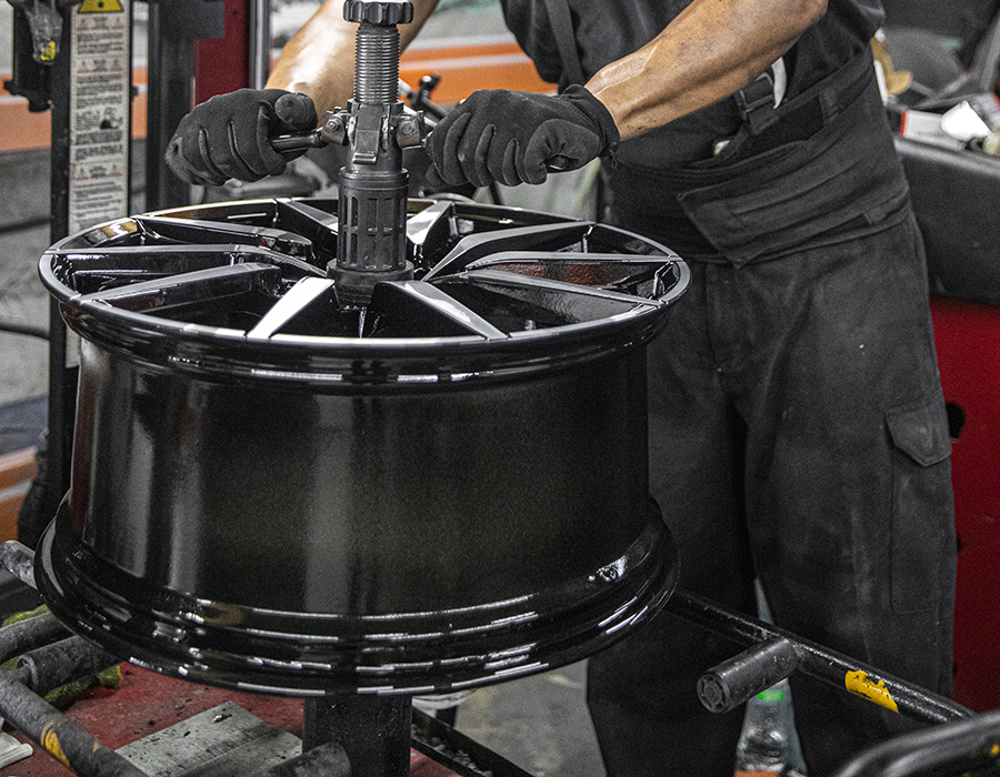 Technician inspecting a wheel before restoration at Wheels Doctor